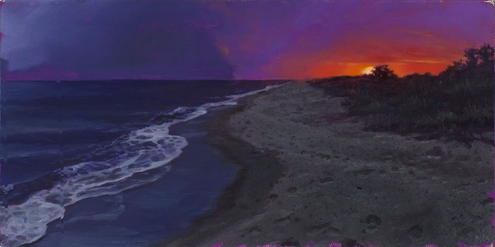A dark sandy beach curves beside foaming waves beneath a purple sky glowing orange-red at the horizon.