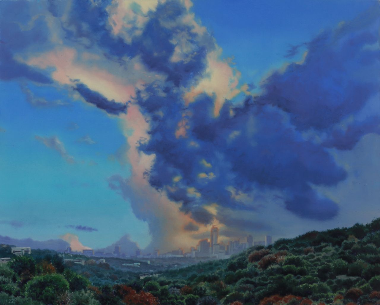 Austin’s distant skyline rises beyond green hills beneath towering blue, violet, and peach-tinted clouds.