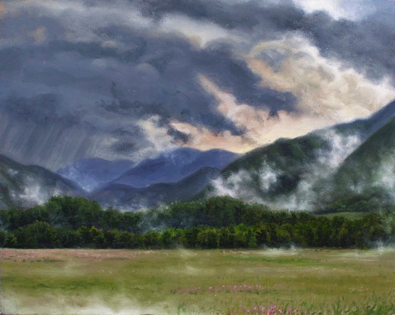 Oil landscape of a green meadow and forest beneath misty blue-green mountains and sweeping dark storm clouds.