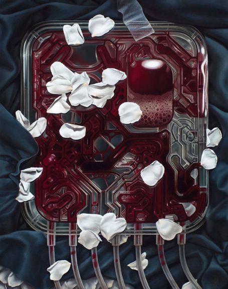 A translucent red mechanical panel with looping channels and dangling tubes lies on dark blue fabric, scattered with white flower petals.
