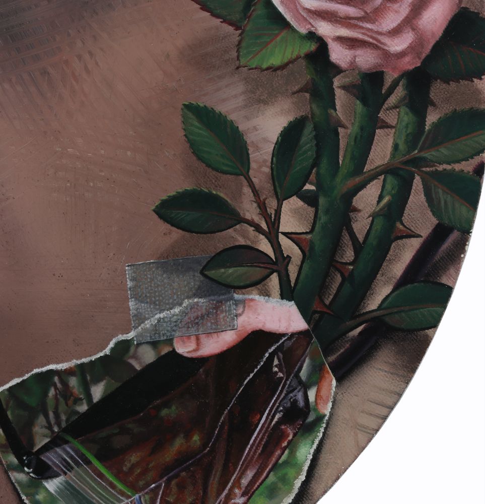 Close detail of a circular painting with a pink rose, thorny green stems, dark leaves, and a pale hand holding a bag of blood.