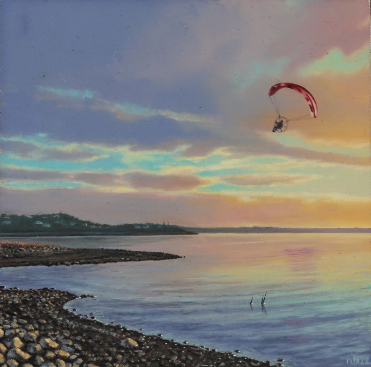 A red-canopied paraglider crosses a pastel sunset sky above calm blue water and a dark, rocky shoreline.