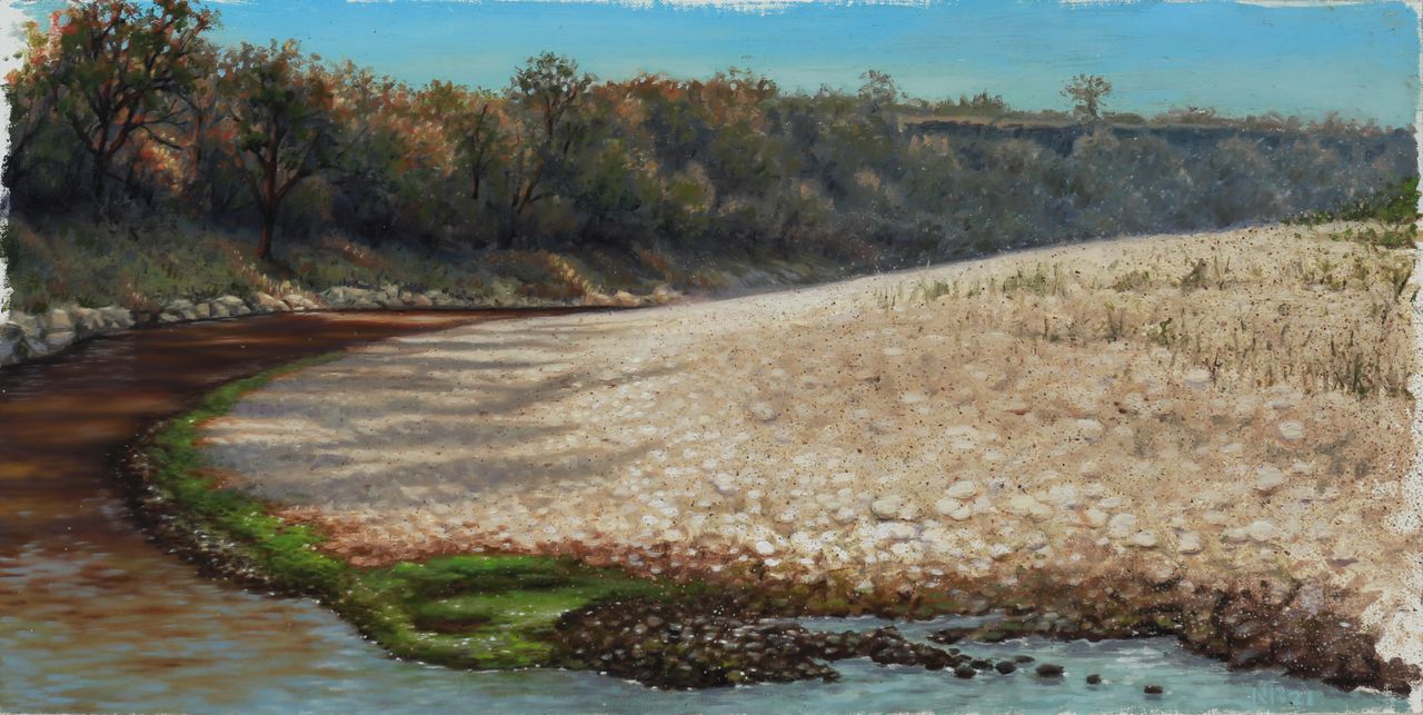 Panoramic landscape painting of a curving river beside a pale rocky bank, backed by dense autumnal trees under a bright blue sky.