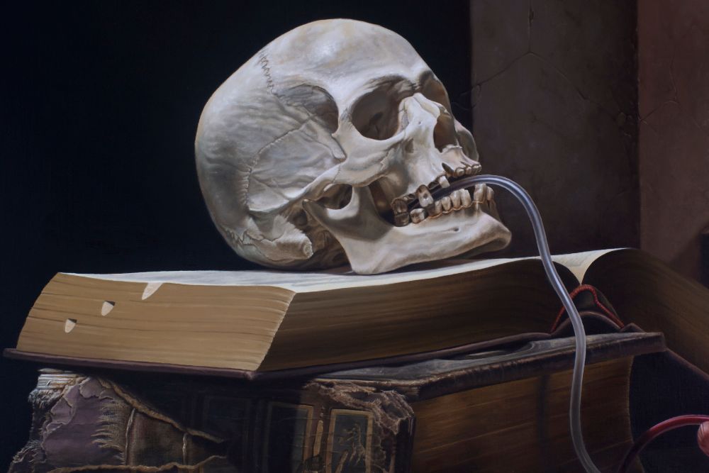 A pale human skull bites a translucent tube while resting atop stacked, worn books against a dark background.