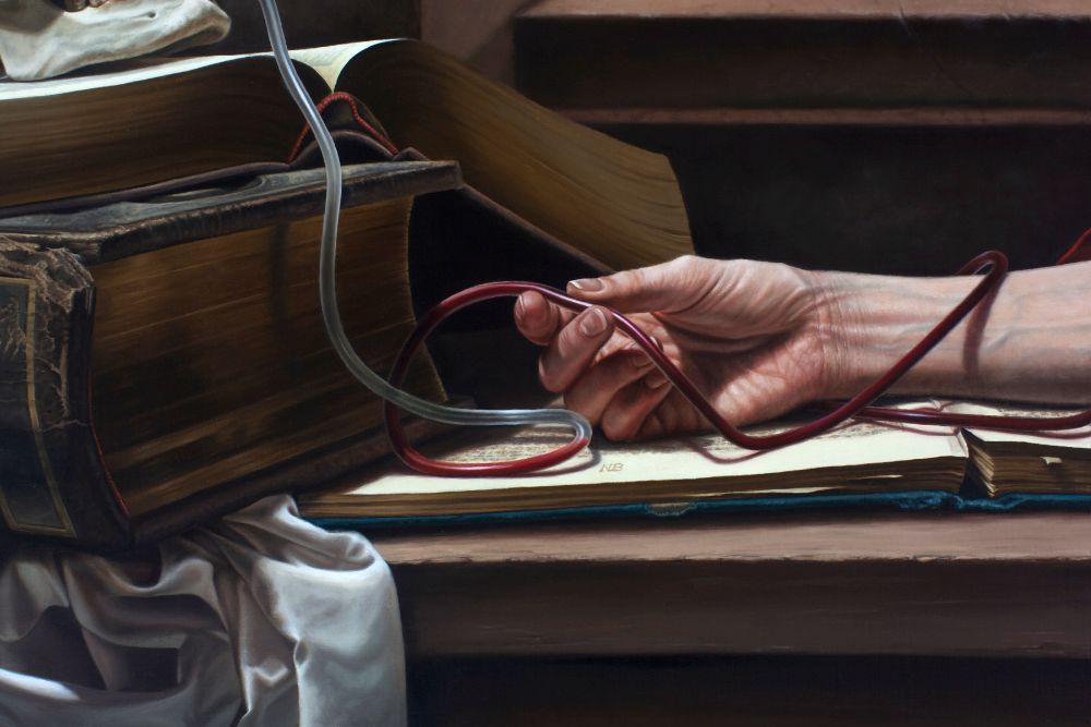 A pale hand loosely holds a looping red blood collection tube over an open book beside stacked worn volumes and draped silver fabric.