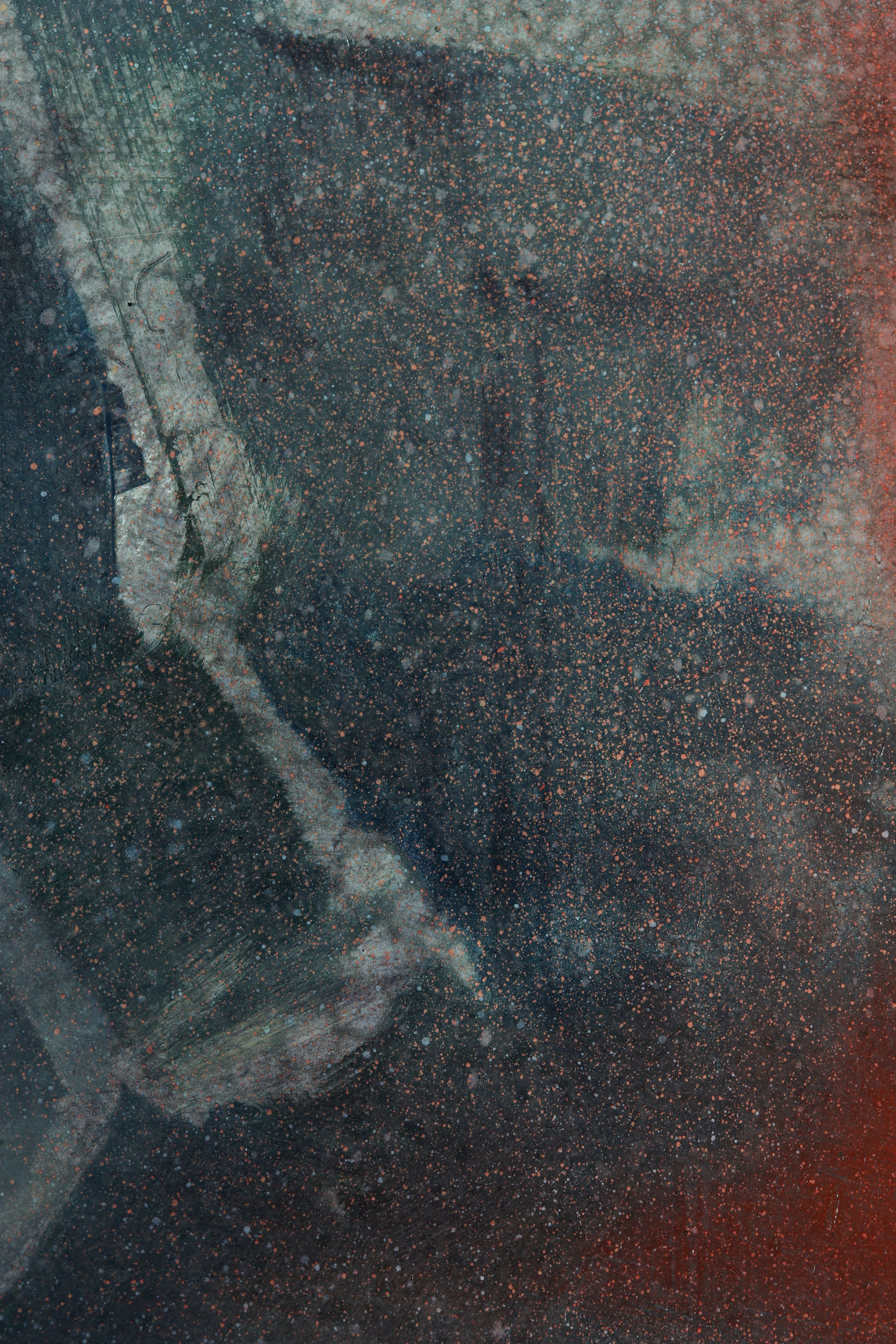 A pale gray curved form crosses a dark blue-black field densely speckled with orange-red dots and glowing red along the right edge.