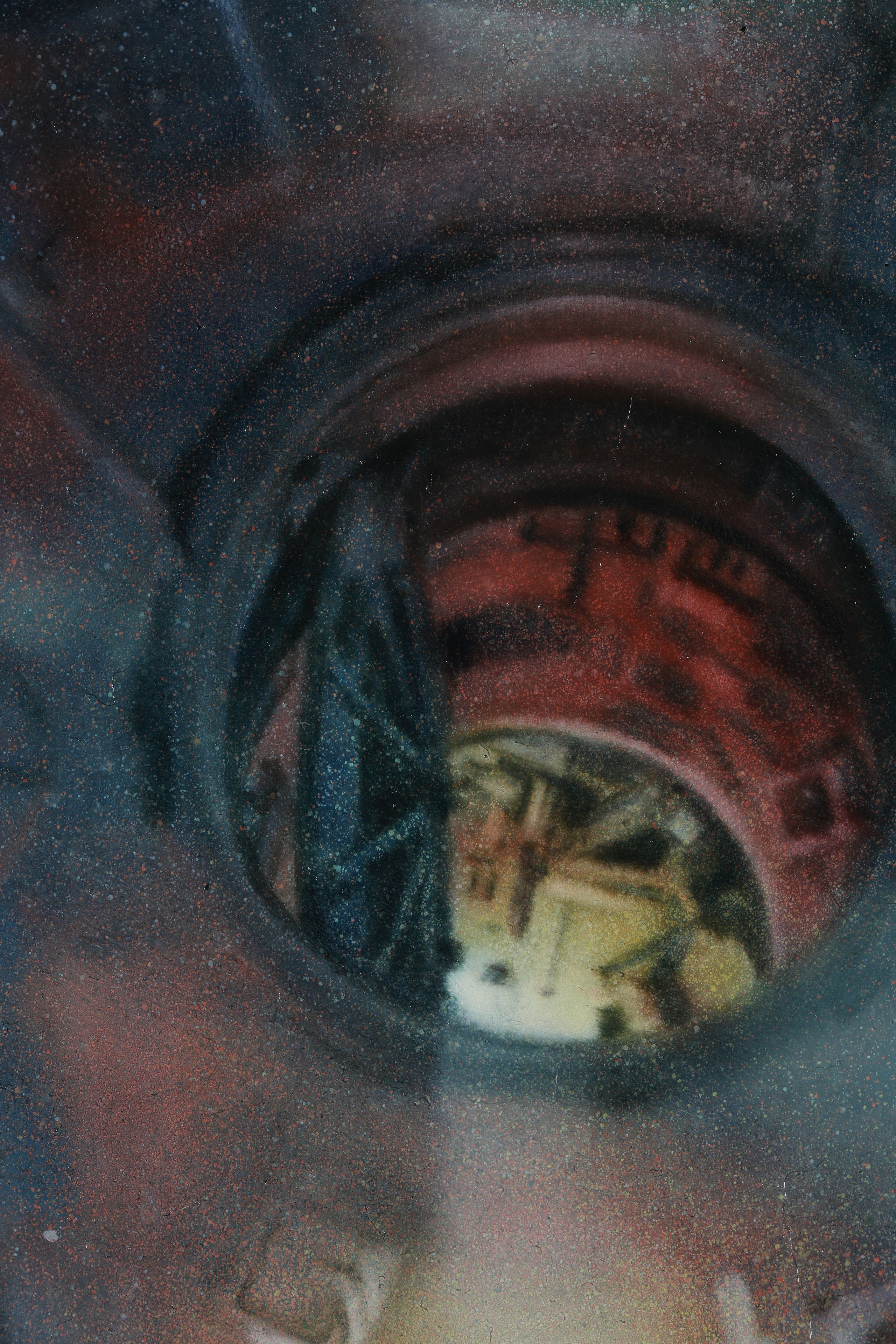A close-up circular rocket entry portal, surrounded by deep blue and red shadows and dense multicoloured speckles.