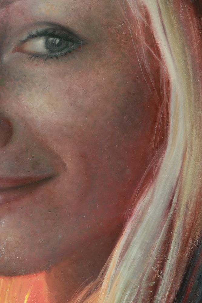 Close detail of a sun-reddened face with one heavily lined eye, a faint smile, and long pale blonde hair.