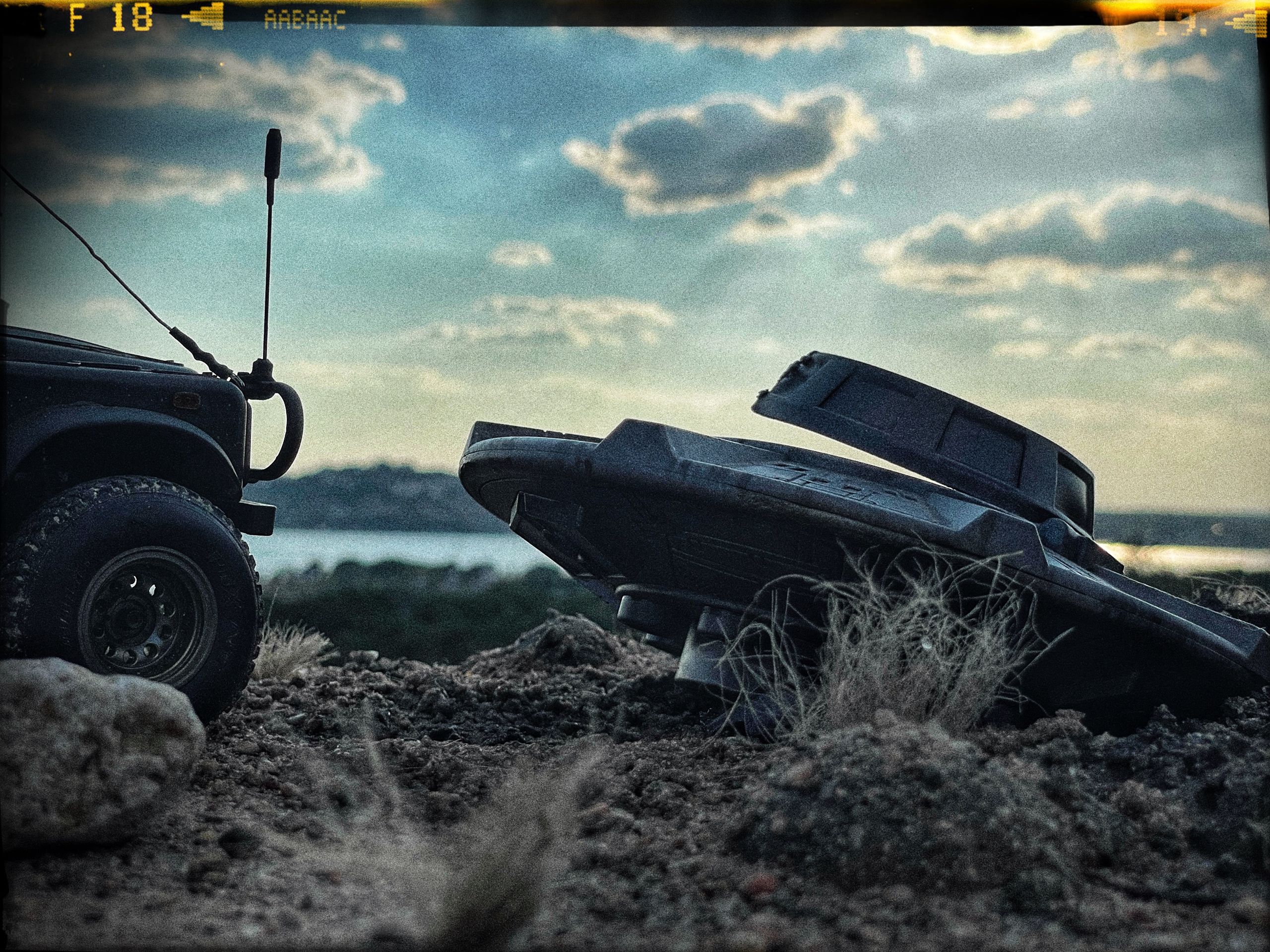 1/24 scale diorama with UFO depicting the Roswell Incident, with desert landscape made from found materials, real dirt and rocks, modeling supplies, with 1/24 scale rugged overlanding Land Rover Defender 110.