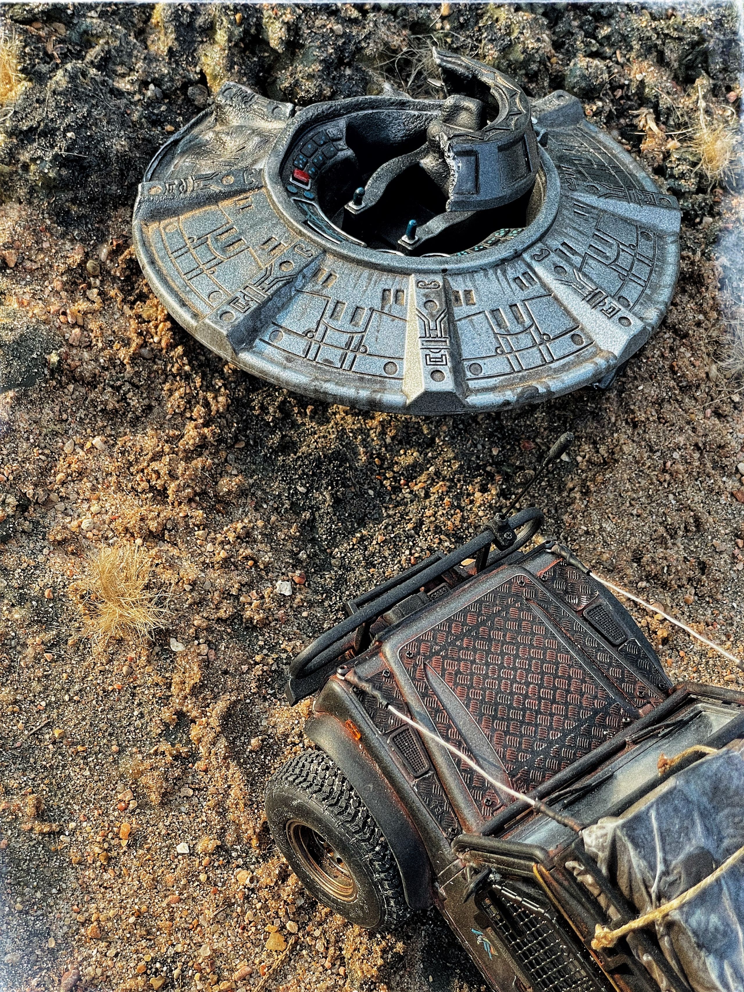 1/24 scale diorama with UFO depicting the Roswell Incident, with desert landscape made from found materials, real dirt and rocks, modeling supplies, with 1/24 scale rugged overlanding Land Rover Defender 110.