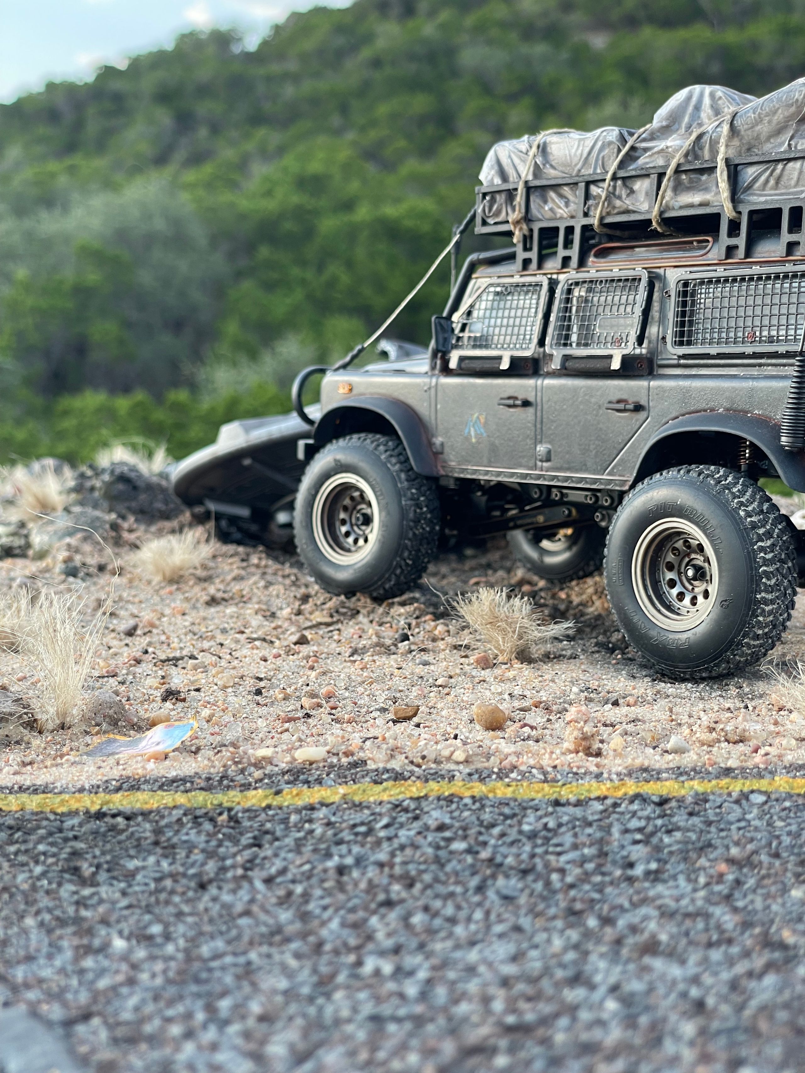 1/24 scale diorama with UFO depicting the Roswell Incident, with desert landscape made from found materials, real dirt and rocks, modeling supplies, with 1/24 scale rugged overlanding Land Rover Defender 110.