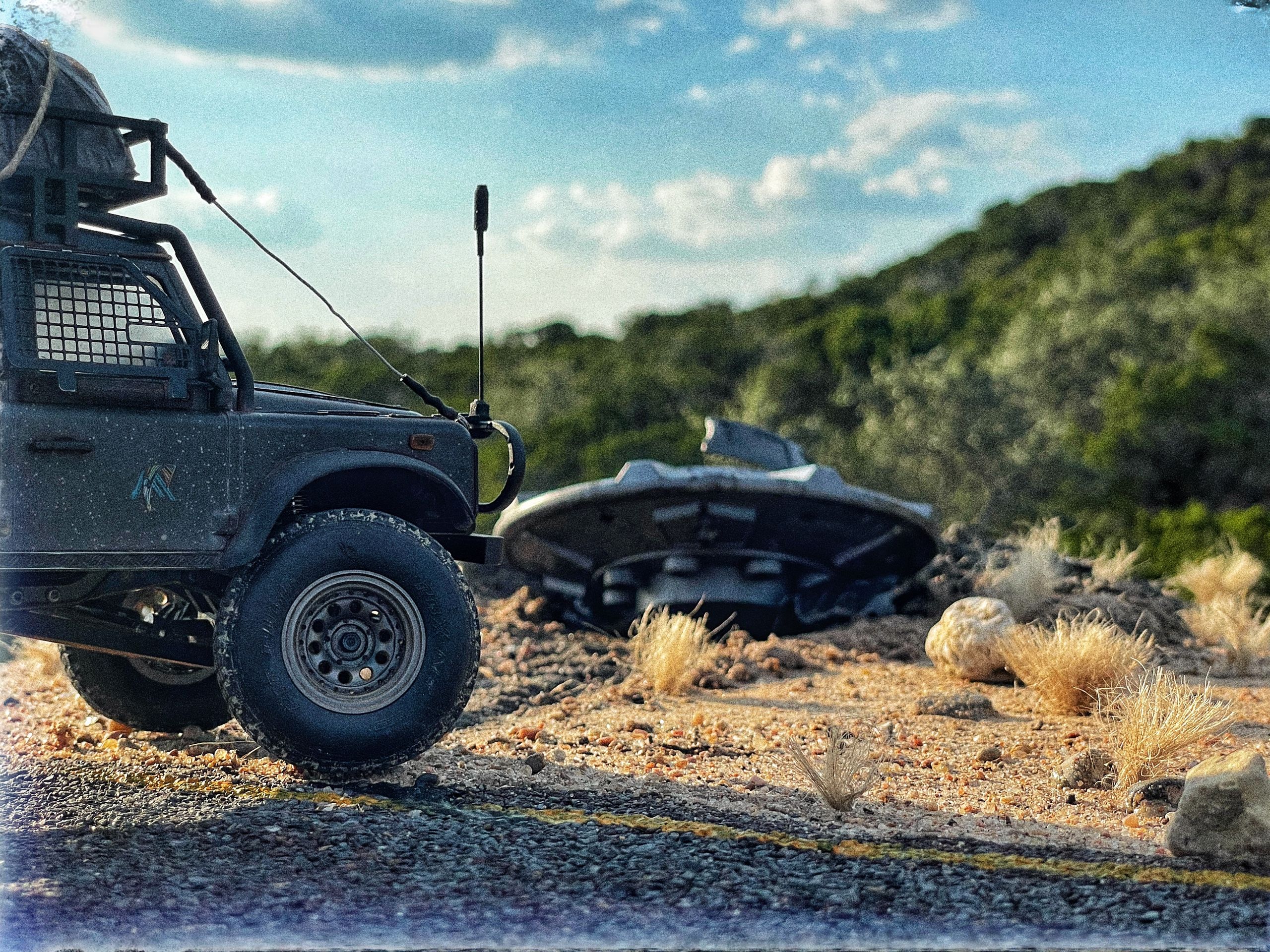 1/24 scale diorama with UFO depicting the Roswell Incident, with desert landscape made from found materials, real dirt and rocks, modeling supplies, with 1/24 scale rugged overlanding Land Rover Defender 110.