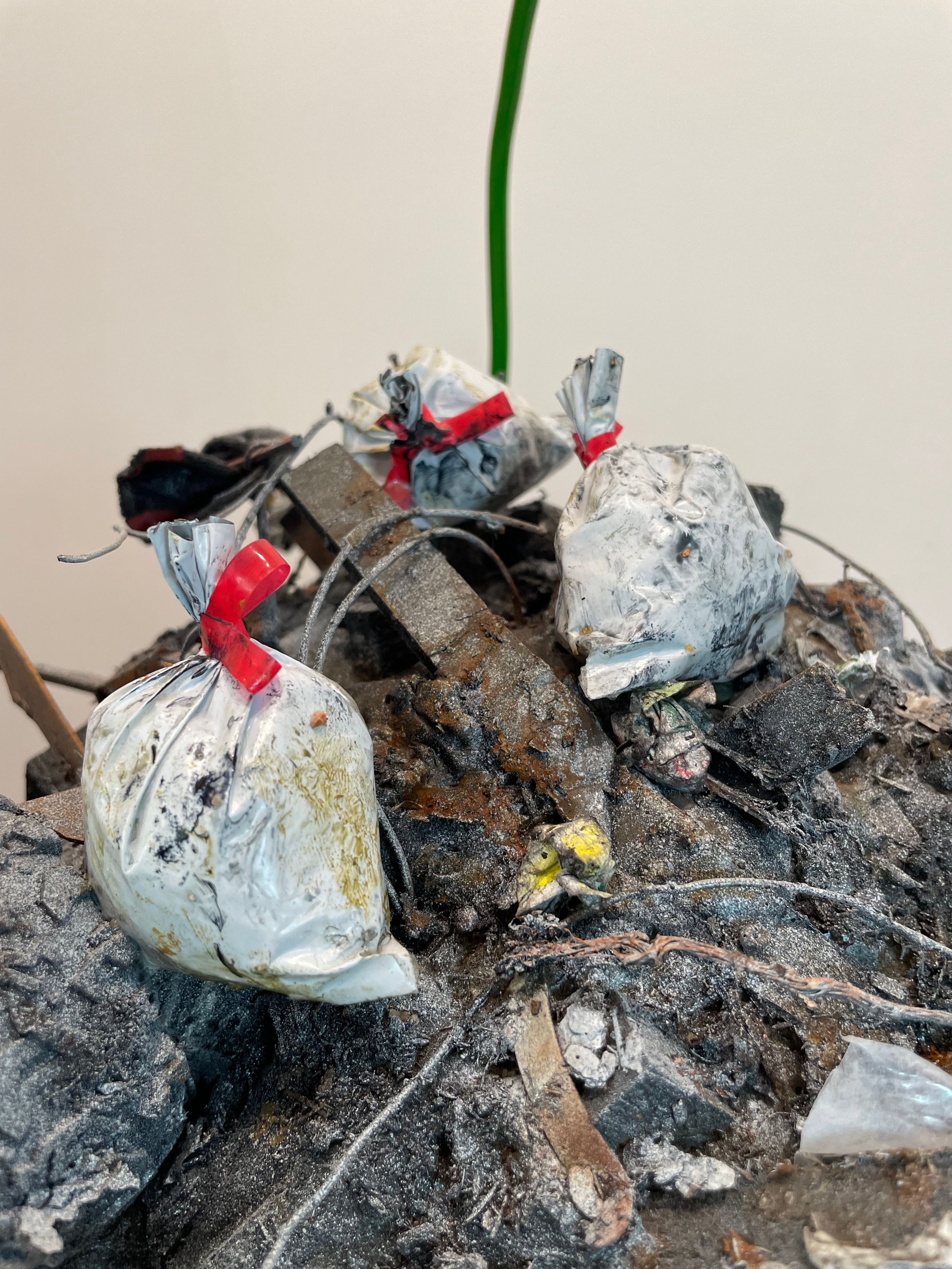 Sculpture made from Plastic, wood, foam, metal, wire, fabric, paint, paper, rubber, cardboard, CA glue, dirt, found objects with commentary on unsustainable economic, urban, and population growth on a finite planet, with a green stock market ticker rising above the wasteland symbolizing the piece's title, a popular stock market and cryptocurrency slogan