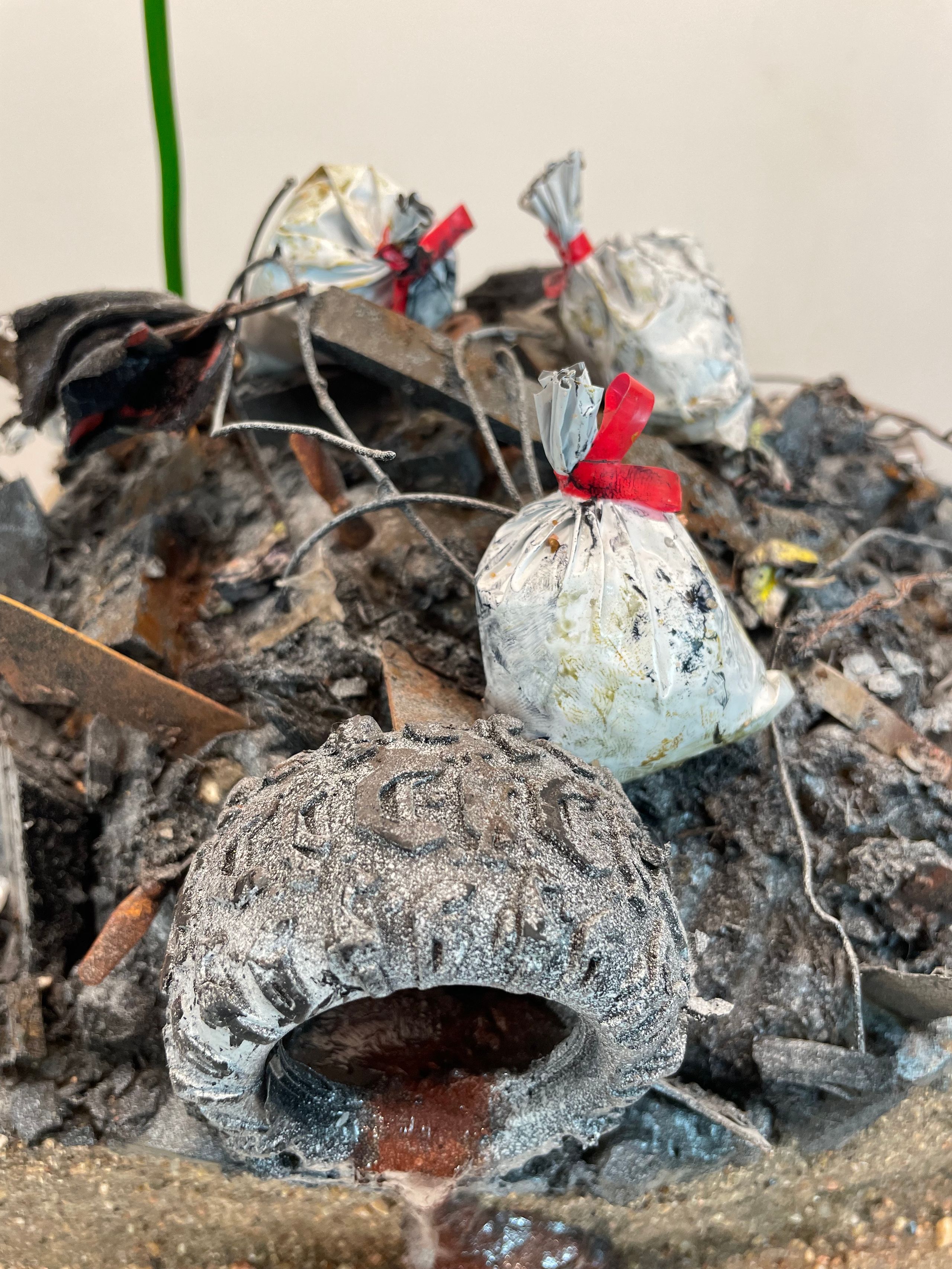 Sculpture made from Plastic, wood, foam, metal, wire, fabric, paint, paper, rubber, cardboard, CA glue, dirt, found objects with commentary on unsustainable economic, urban, and population growth on a finite planet, with a green stock market ticker rising above the wasteland symbolizing the piece's title, a popular stock market and cryptocurrency slogan