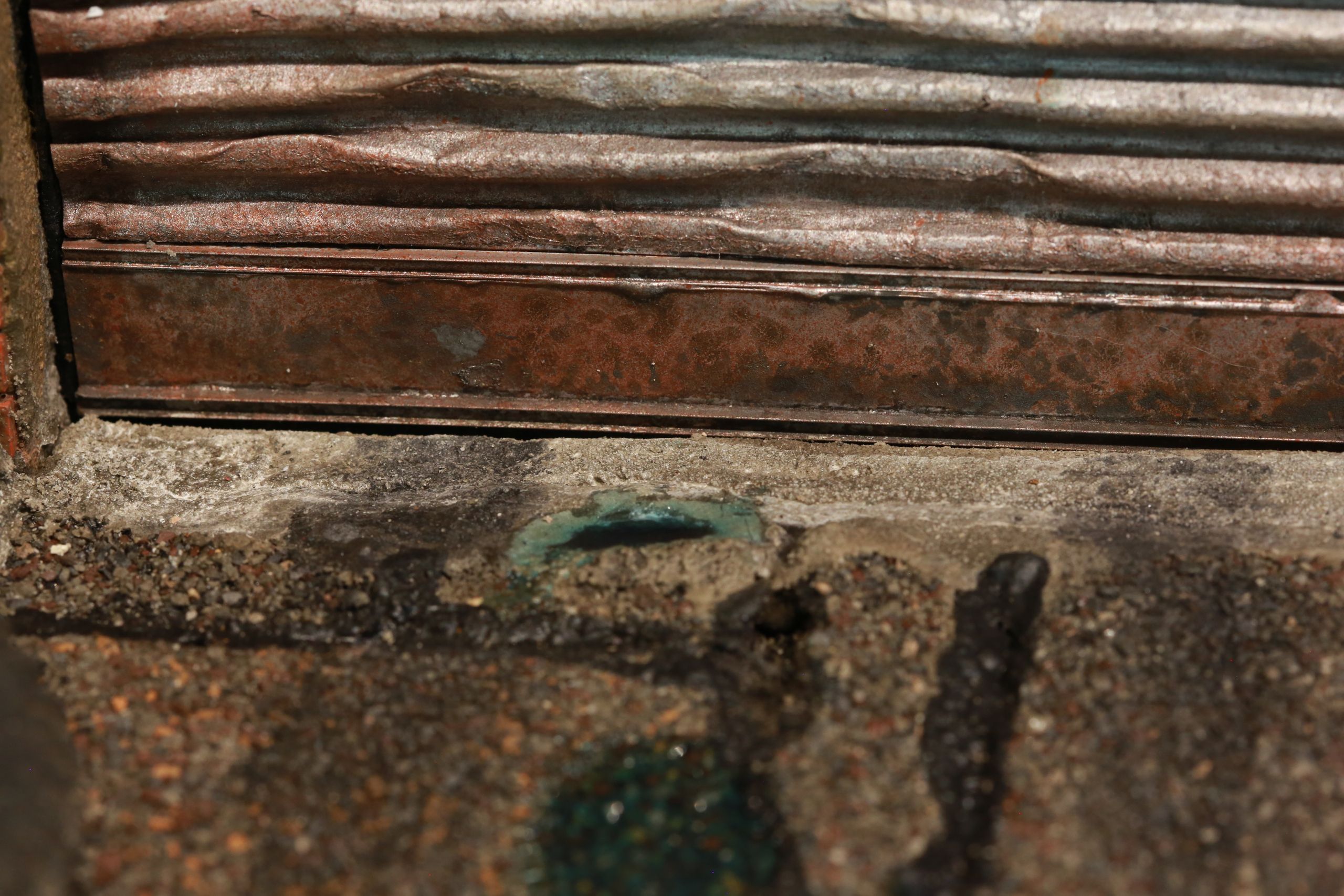 1/24-1/18 scale miniature diorama of a bombed out post apocalyptic inner city street alley way, with corrugated steel auto garage bay door, graffiti mural, and Frank Lloyd Wright Ennis House tiles