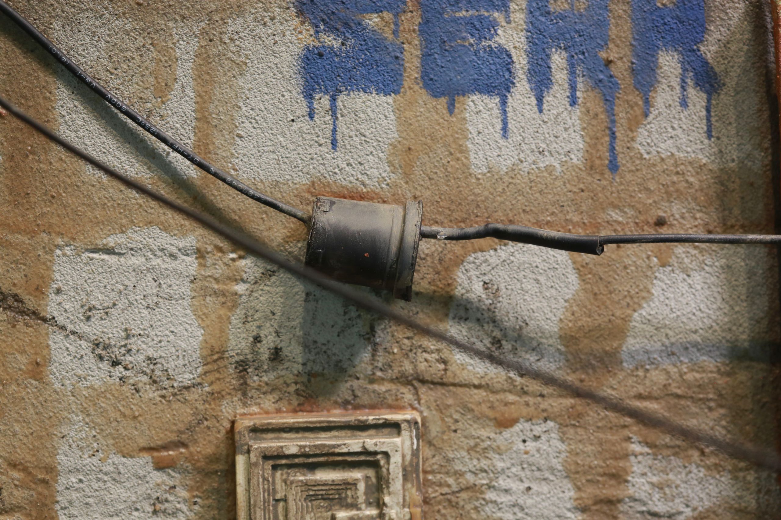 1/24-1/18 scale miniature diorama of a bombed out post apocalyptic inner city street alley way, with corrugated steel auto garage bay door, graffiti mural, and Frank Lloyd Wright Ennis House tiles