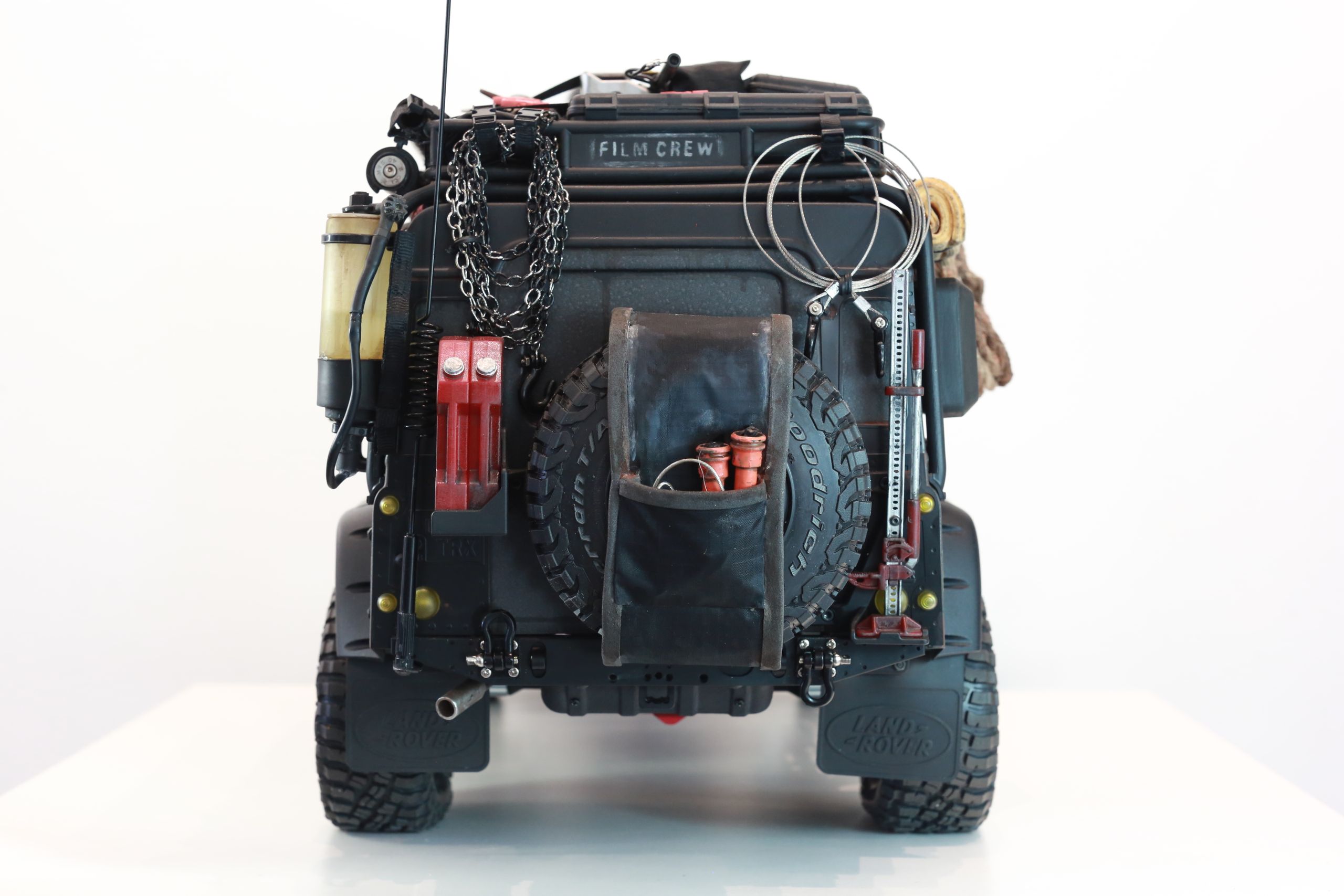 1/10 scale RC Defender 110 build inspired by the heavily modified and customized Land Rover Defenders used by National Geographic photographers in the 80s and 90s in places like the African savanna, featuring a custom cab interior and rear camera platforms, as well as many handmade accessories constructed from found objects and household junk.