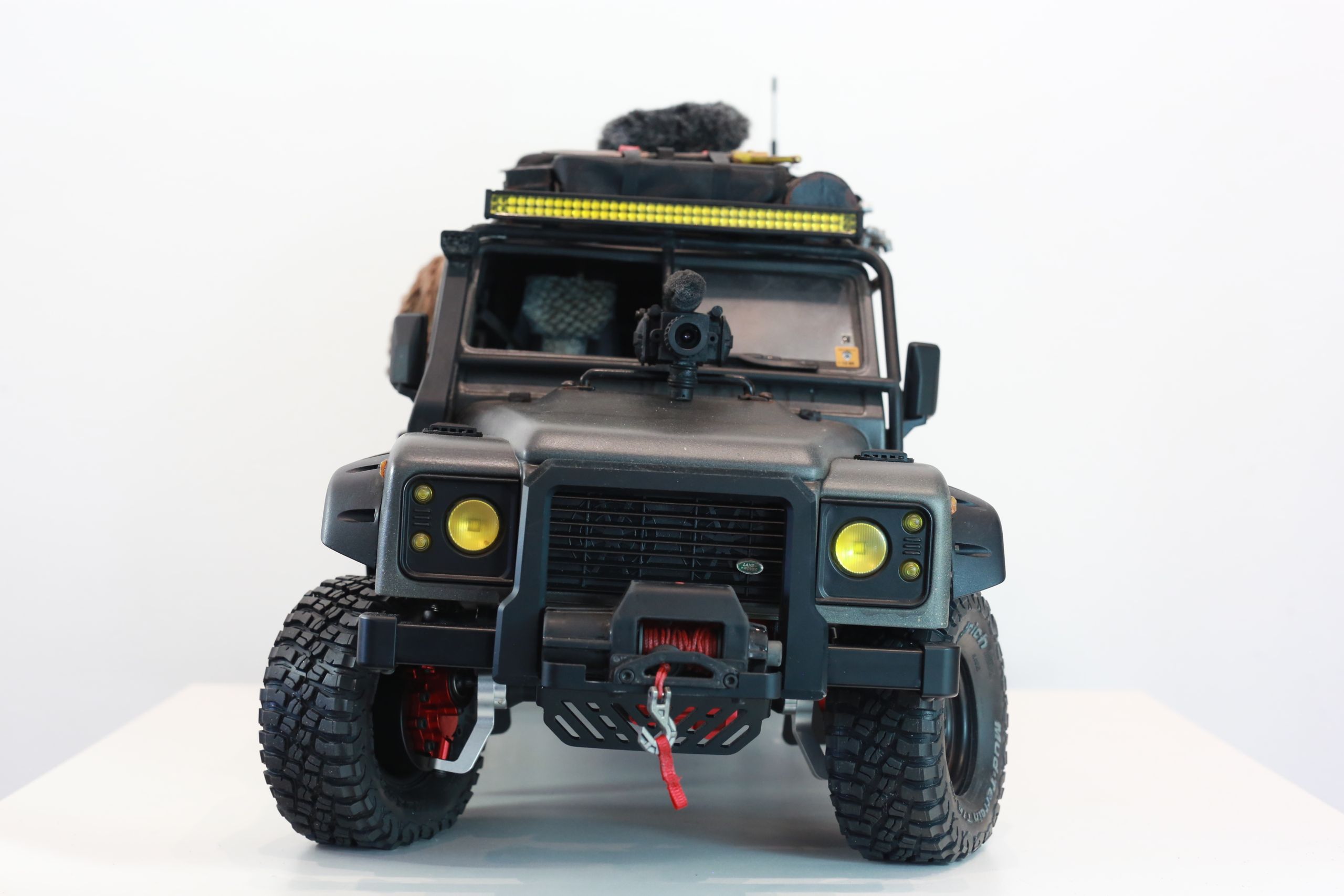 1/10 scale RC Defender 110 build inspired by the heavily modified and customized Land Rover Defenders used by National Geographic photographers in the 80s and 90s in places like the African savanna, featuring a custom cab interior and rear camera platforms, as well as many handmade accessories constructed from found objects and household junk.