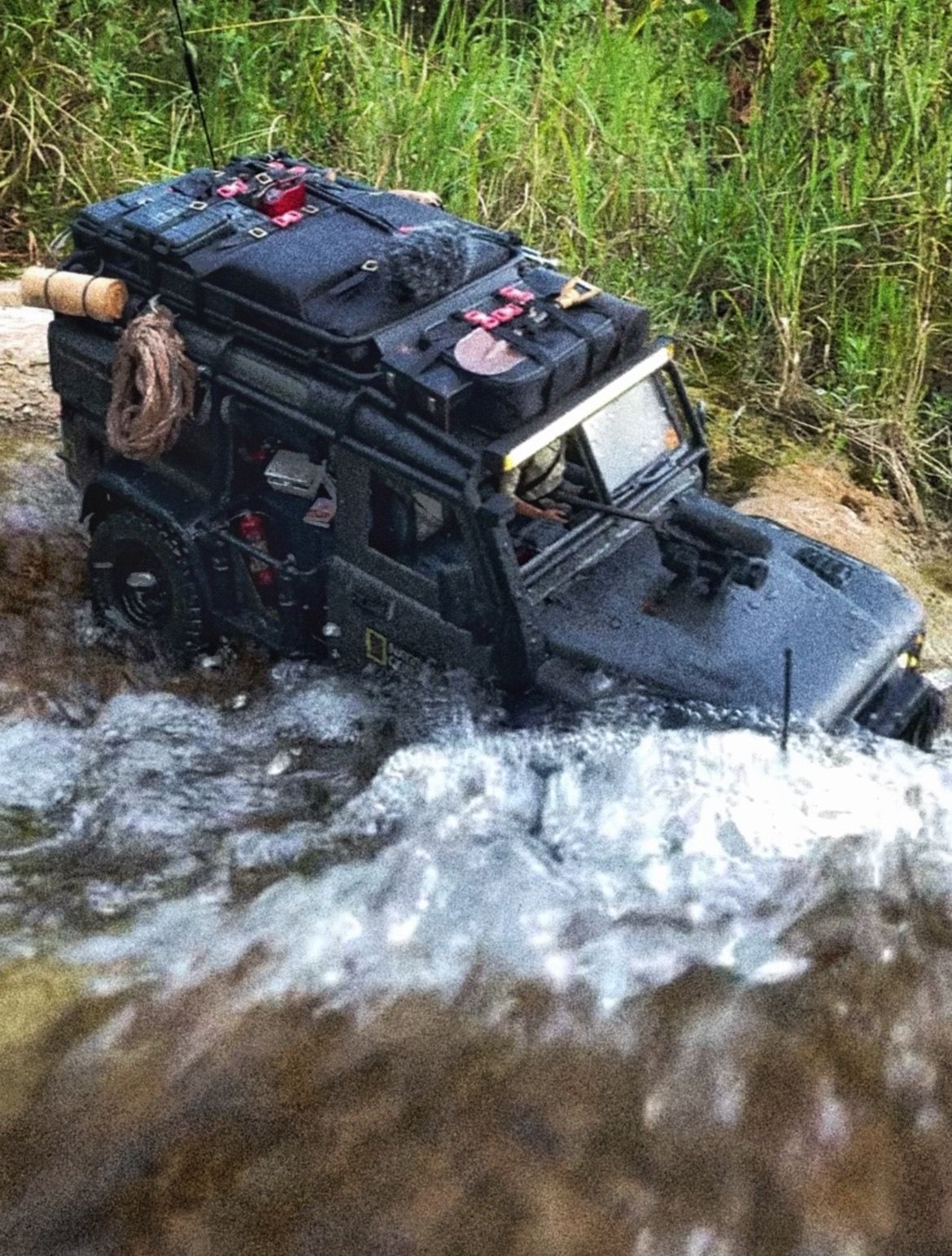 1/10 scale RC Defender 110 build inspired by the heavily modified and customized Land Rover Defenders used by National Geographic photographers in the 80s and 90s in places like the African savanna, featuring a custom cab interior and rear camera platforms, as well as many handmade accessories constructed from found objects and household junk.
