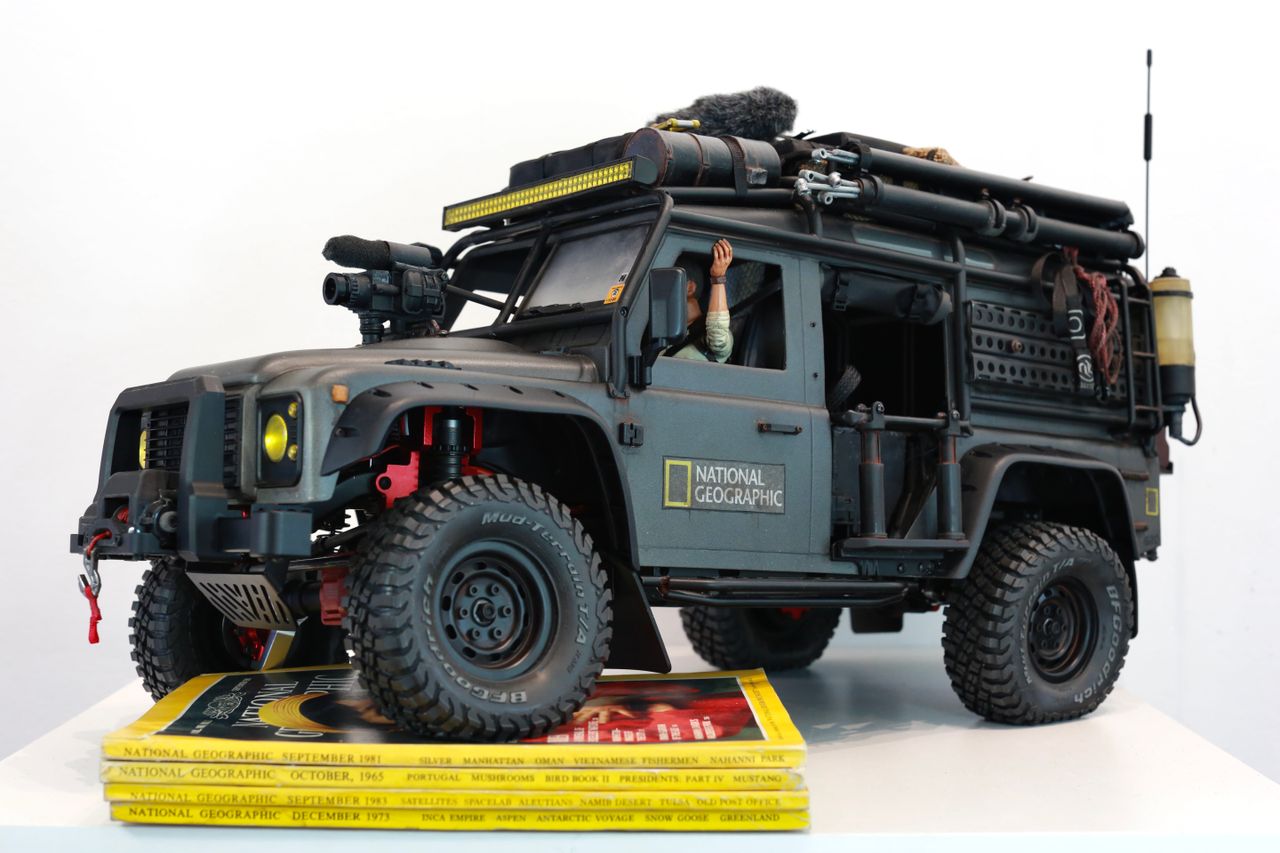 1/10 scale RC Defender 110 build inspired by the heavily modified and customized Land Rover Defenders used by National Geographic photographers in the 80s and 90s in places like the African savanna, featuring a custom cab interior and rear camera platforms, as well as many handmade accessories constructed from found objects and household junk.