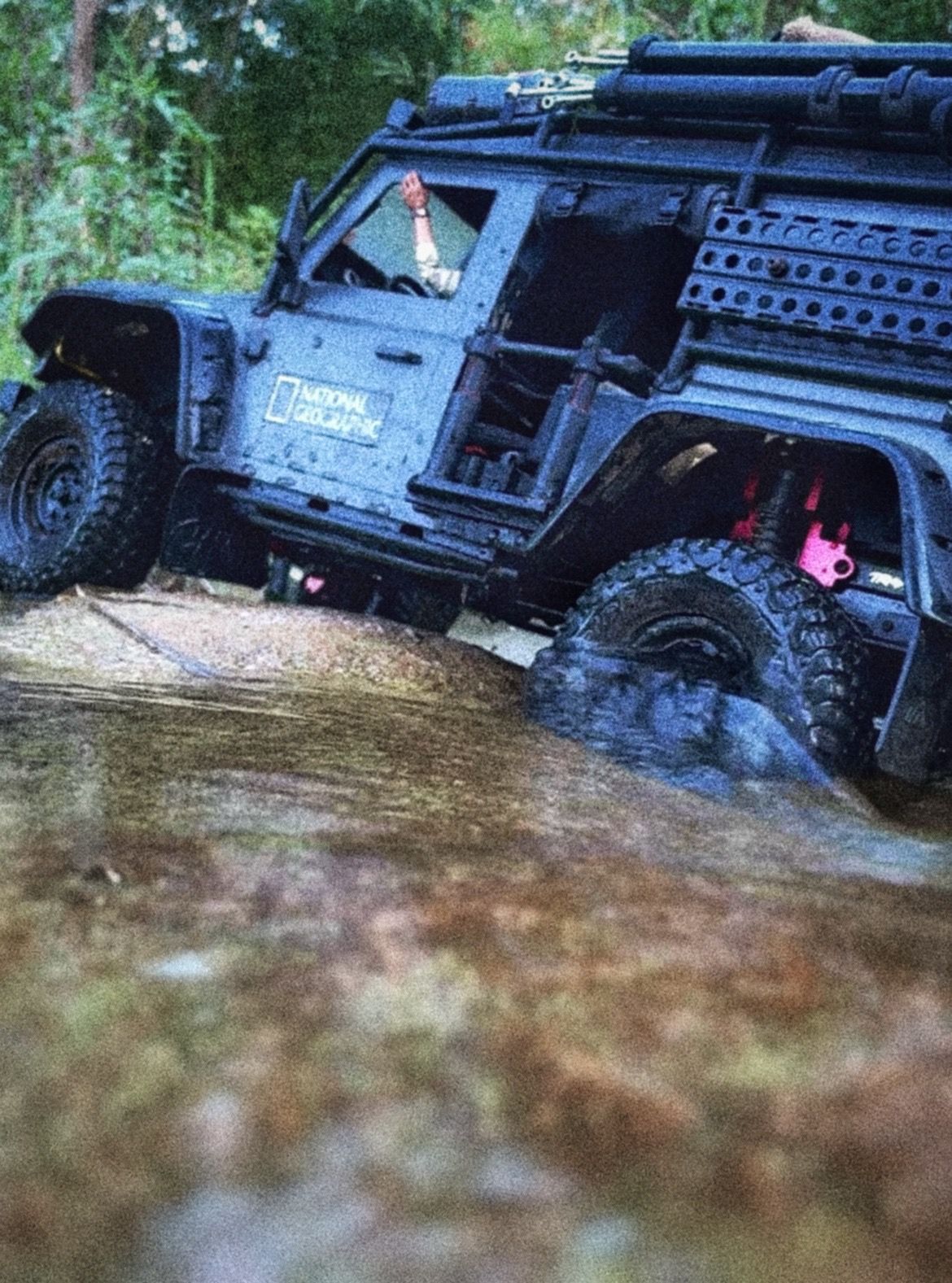 1/10 scale RC Defender 110 build inspired by the heavily modified and customized Land Rover Defenders used by National Geographic photographers in the 80s and 90s in places like the African savanna, featuring a custom cab interior and rear camera platforms, as well as many handmade accessories constructed from found objects and household junk.