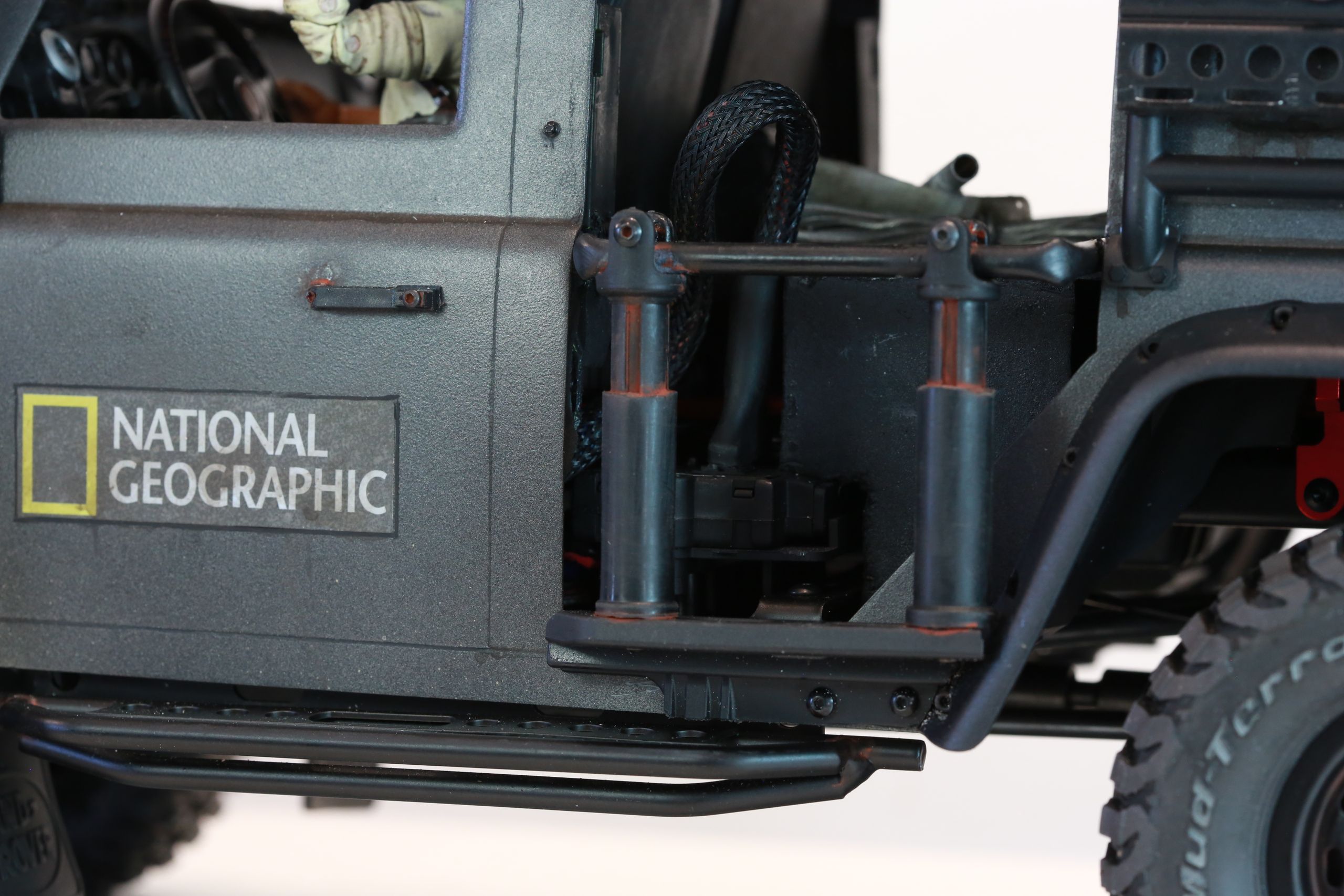 1/10 scale RC Defender 110 build inspired by the heavily modified and customized Land Rover Defenders used by National Geographic photographers in the 80s and 90s in places like the African savanna, featuring a custom cab interior and rear camera platforms, as well as many handmade accessories constructed from found objects and household junk.