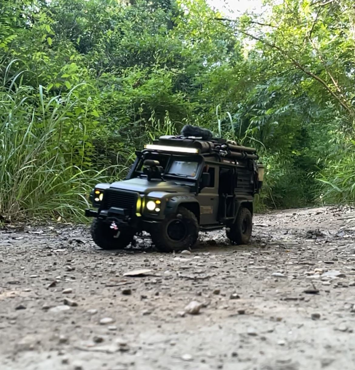 1/10 scale RC Defender 110 build inspired by the heavily modified and customized Land Rover Defenders used by National Geographic photographers in the 80s and 90s in places like the African savanna, featuring a custom cab interior and rear camera platforms, as well as many handmade accessories constructed from found objects and household junk.