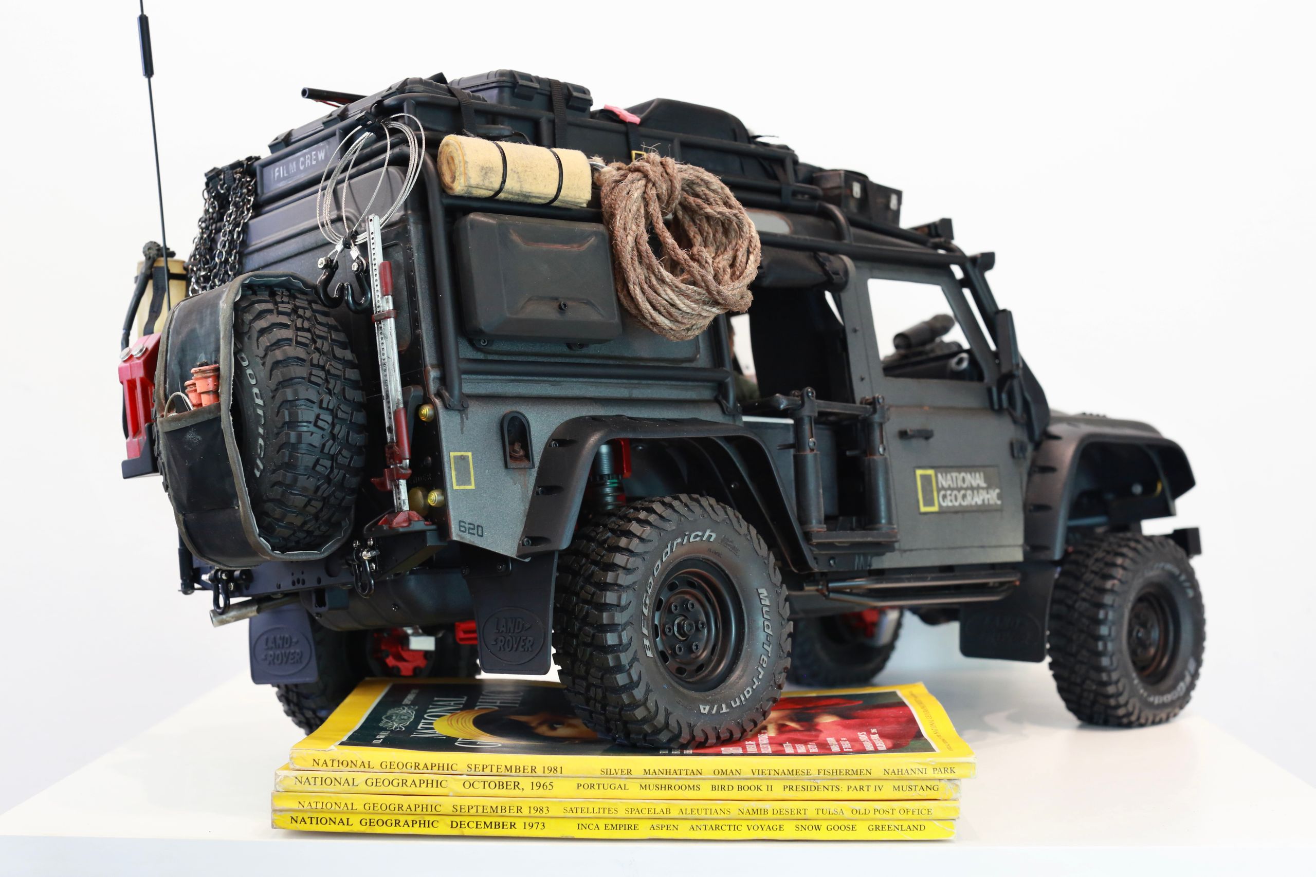 1/10 scale RC Defender 110 build inspired by the heavily modified and customized Land Rover Defenders used by National Geographic photographers in the 80s and 90s in places like the African savanna, featuring a custom cab interior and rear camera platforms, as well as many handmade accessories constructed from found objects and household junk.