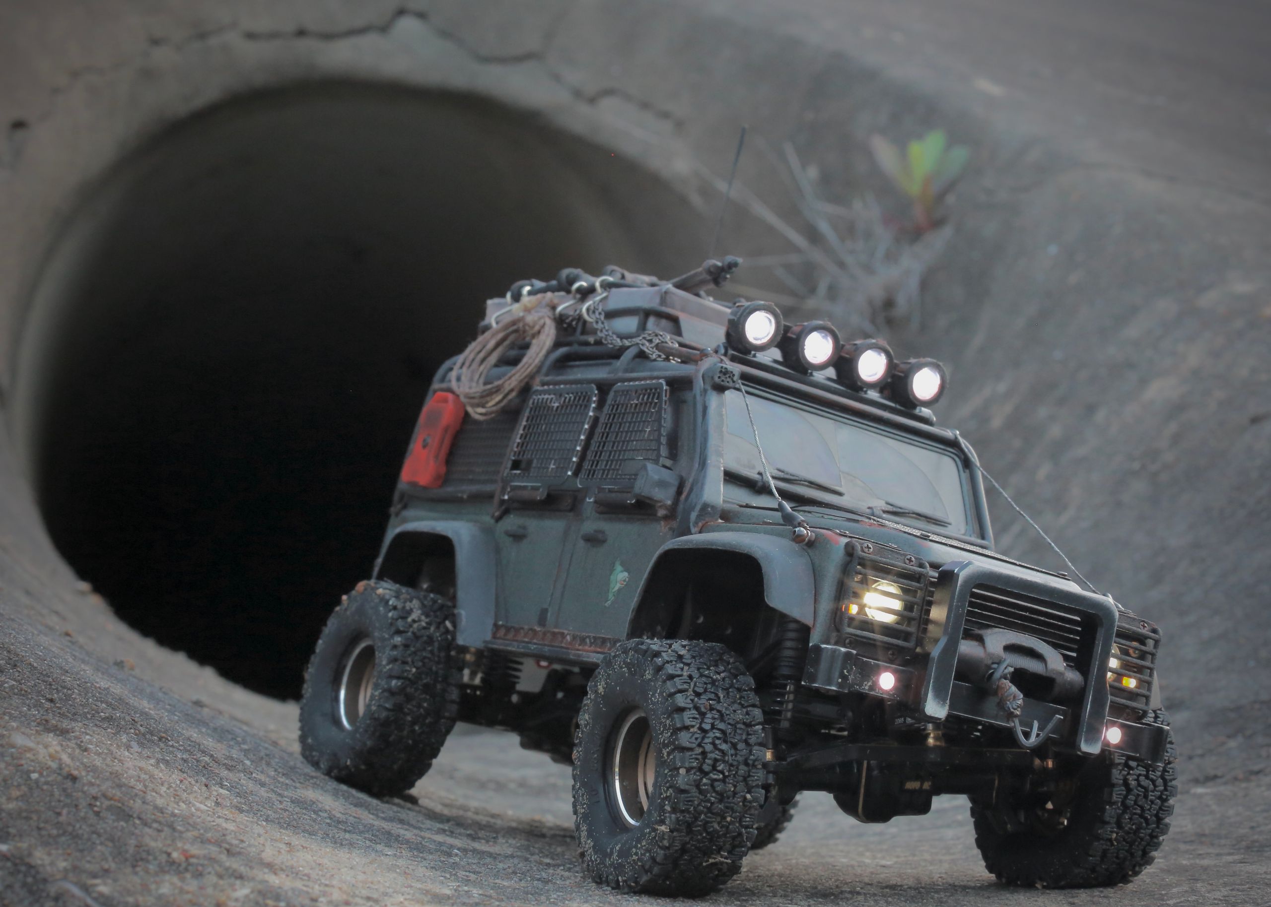 1/18 scale RC Land Rover Defender build inspired by post-apocalyptic franchises like "The Last Of Us" and "28 Days Later" featuring a working winch constructed from a retractable lanyard spool mounted underneath the hood.