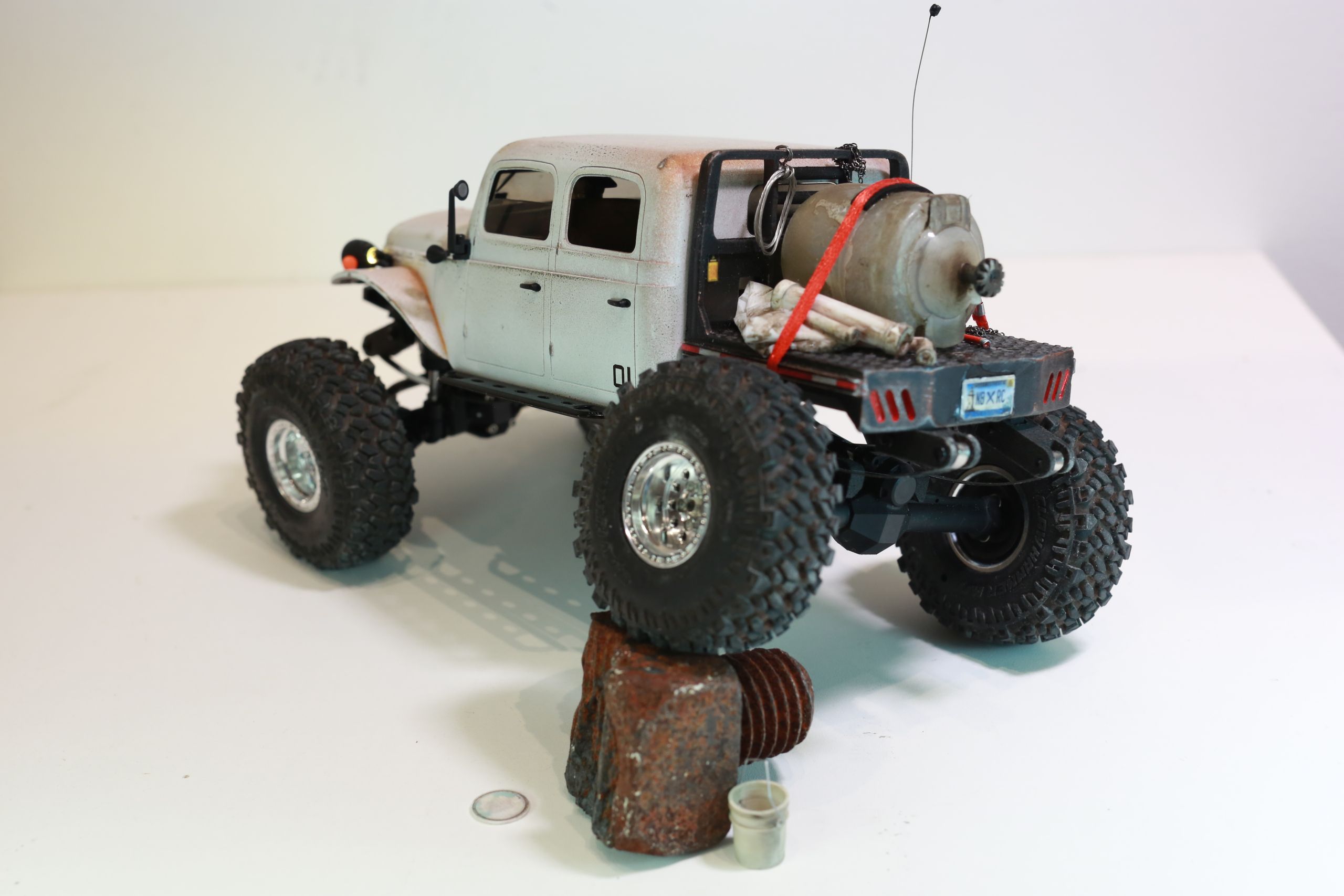 1/24 scale 1950's Dodge Power Wagon RC truck by austin texas artist Nick Baxter with a flatbed hauling a potable water tank and industrial plumbing equipment, riding on a custom leaf spring suspension system designed and tuned by the artist