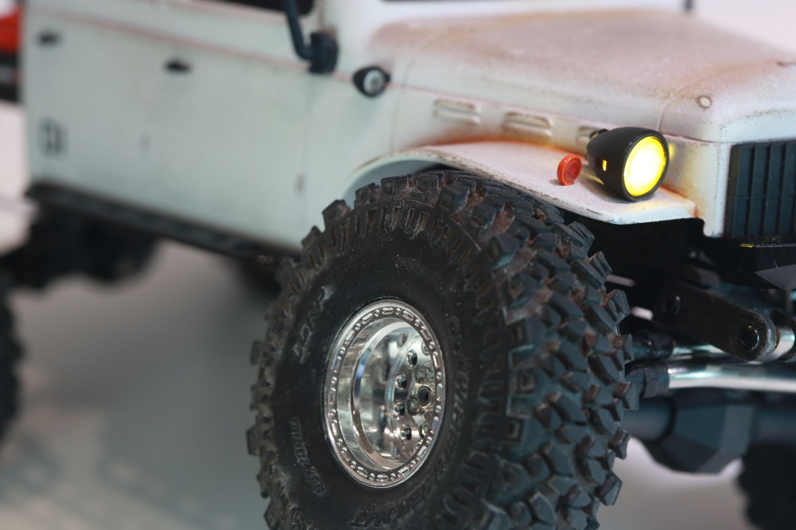 1/24 scale 1950's Dodge Power Wagon RC truck by austin texas artist Nick Baxter with a flatbed hauling a potable water tank and industrial plumbing equipment, riding on a custom leaf spring suspension system designed and tuned by the artist
