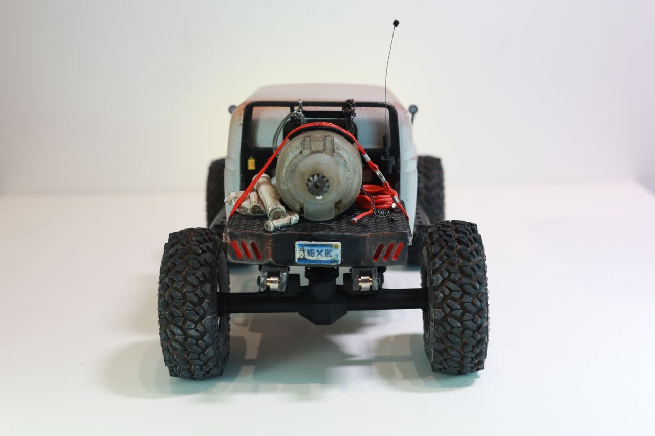 1/24 scale 1950's Dodge Power Wagon RC truck by austin texas artist Nick Baxter with a flatbed hauling a potable water tank and industrial plumbing equipment, riding on a custom leaf spring suspension system designed and tuned by the artist
