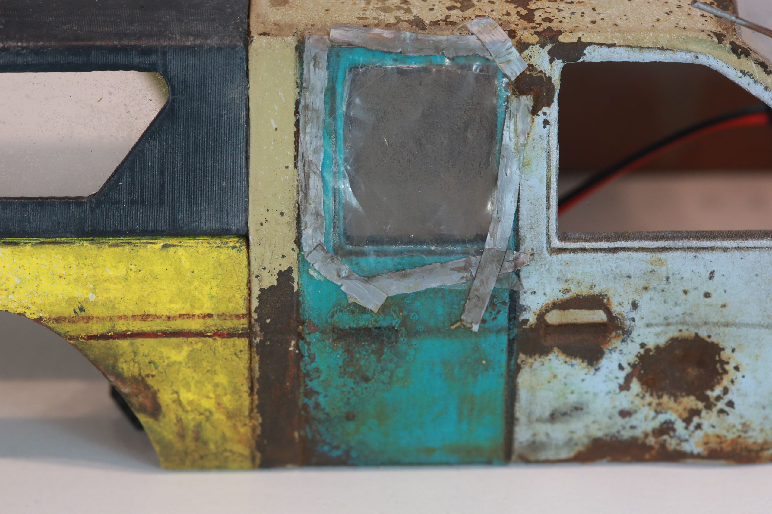 Old junkyard Nissan 1/24 scale 3d printed pickup body for scx24 RC truck with real rust patina, dents, duct tape windows, and custom bumpers.