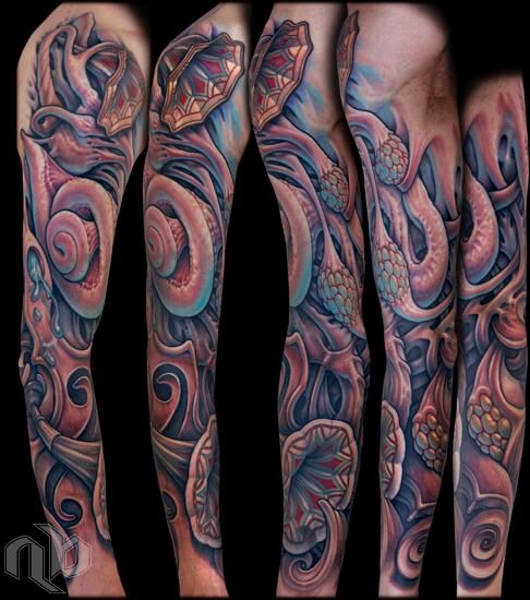 Five angled views show a large arm tattoo of layered organic anatomical inner ear forms, spirals, folds, and clustered nodules in pink, blue, and red.