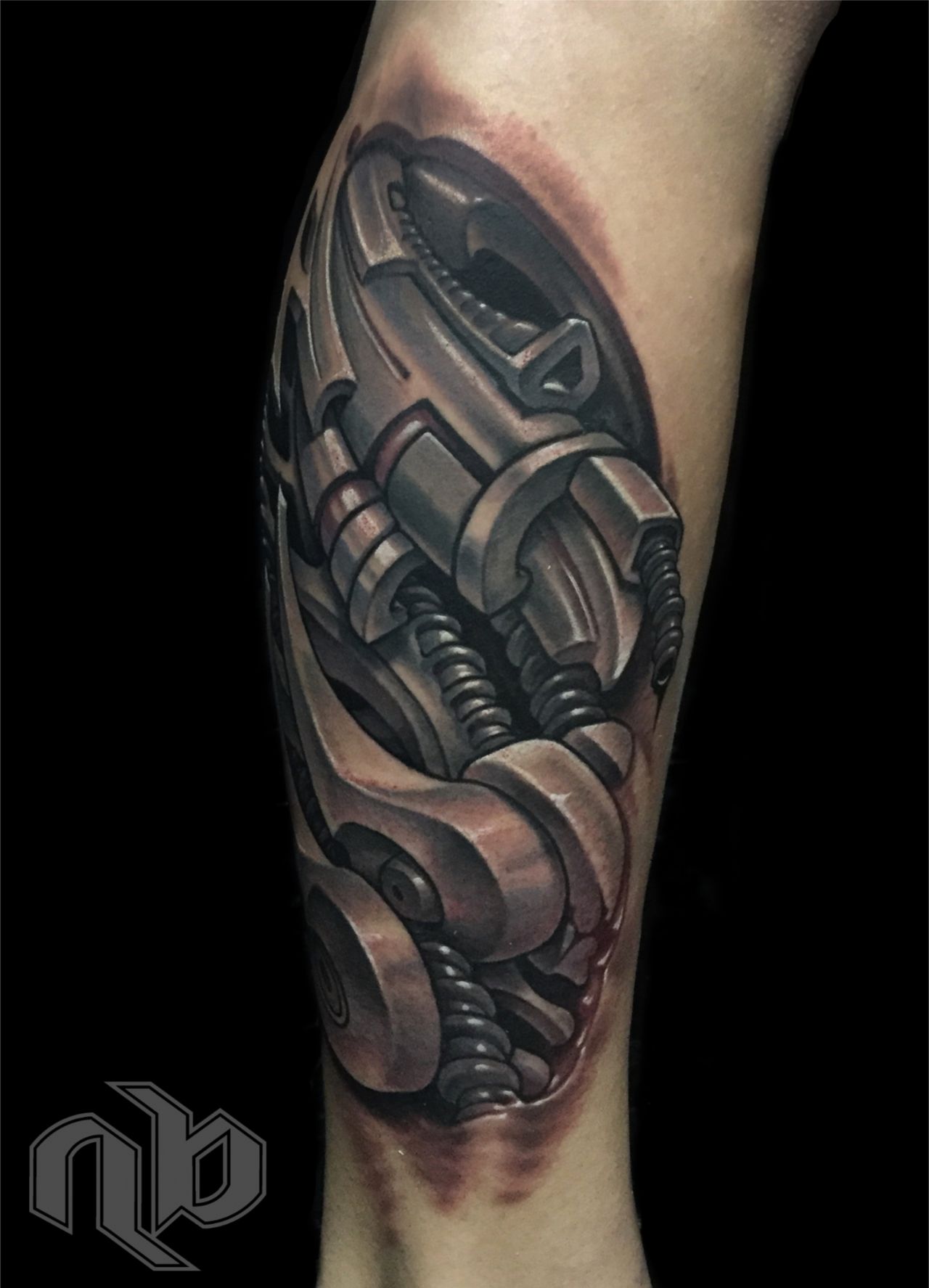 Close view of a medium leg tattoo depicting layered metallic machine parts, coils, bolts, and curved plates in black, grey, and muted red.