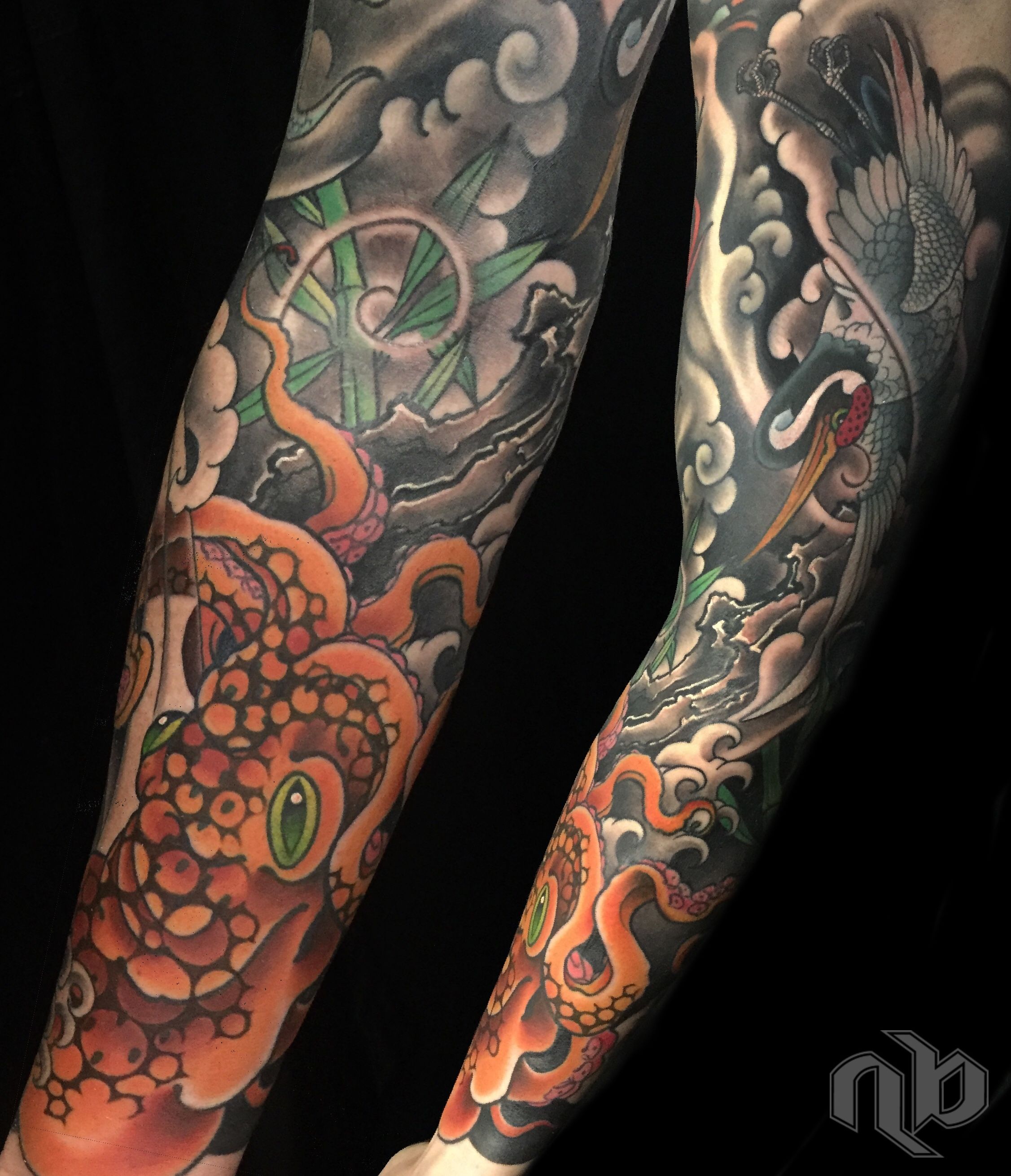 Two close views show a large japanese woodblock print styled arm tattoo of an orange octopus and grey crane amid stylized waves, clouds, and green bamboo.