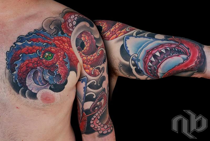 Large arm tattoo showing a red-orange octopus amid blue waves facing a blue shark with open jaws and sharp teeth.
