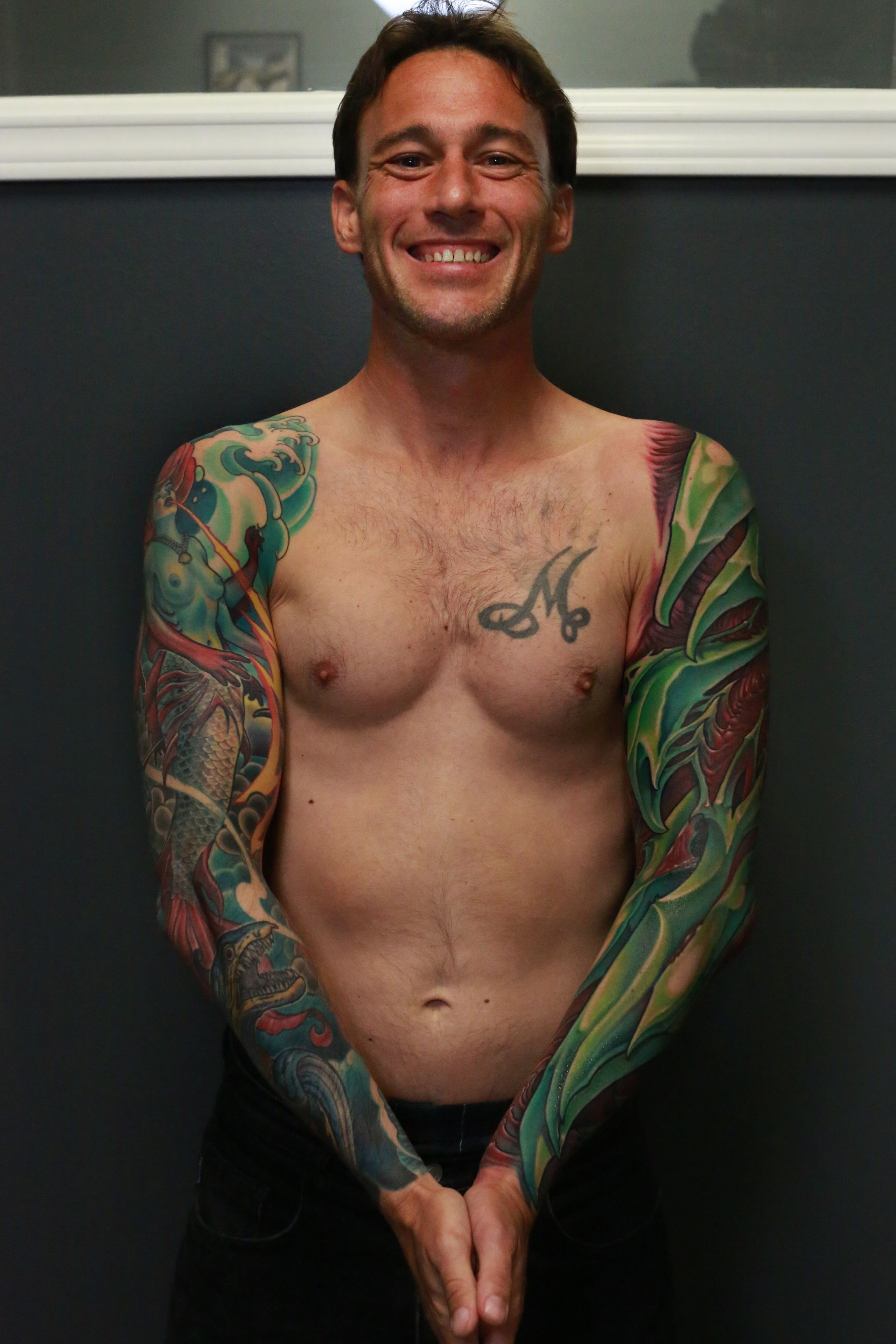 green and red bio organic sleeve tattoo inspired by parrot bird colors and shapes.