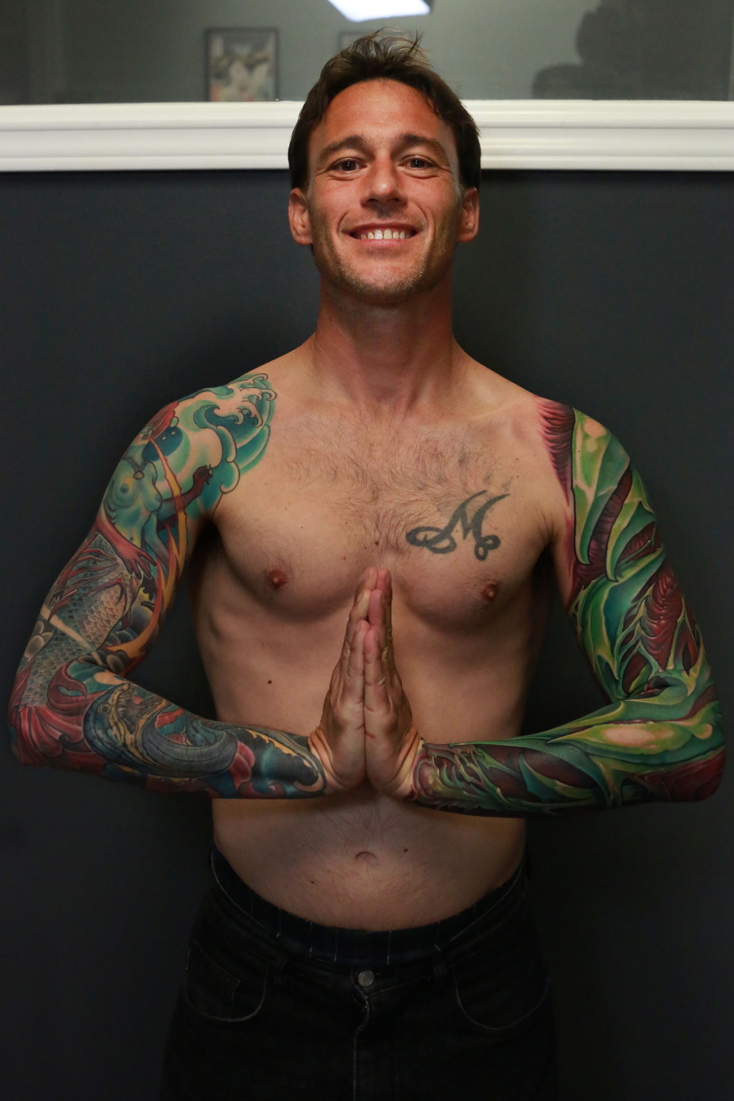 green and red bio organic sleeve tattoo inspired by parrot bird colors and shapes.