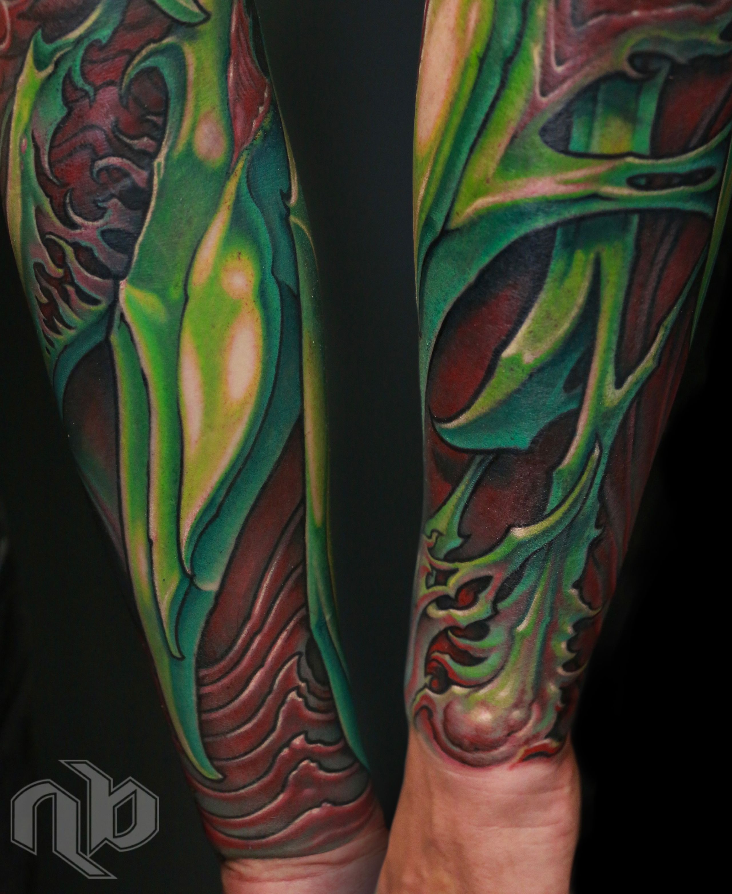 green and red bio organic sleeve tattoo inspired by parrot bird colors and shapes.