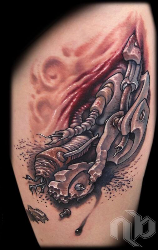 Close view of a small leg tattoo depicting metallic broken machinery emerging through a red-edged fleshy opening, with scattered dark droplets.