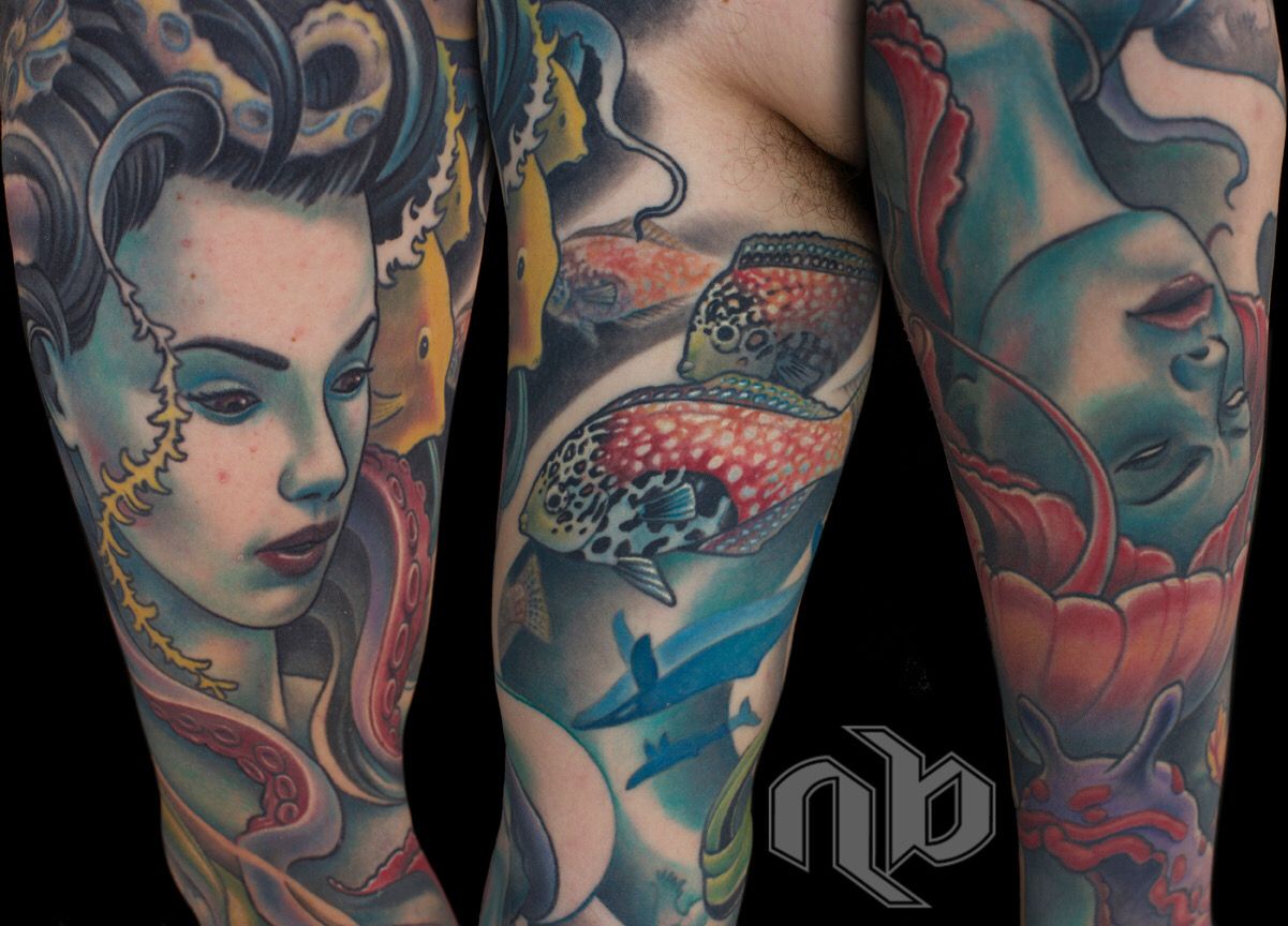 Three views of a large arm tattoo show stylized faces, octopus tentacles, spotted fish, sharks, and coral in teal, red, and yellow.