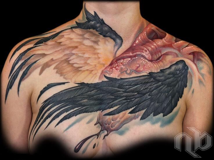 Medium chest tattoo of a red anatomical heart with one pale feathered wing and one dark wing spanning the upper torso.