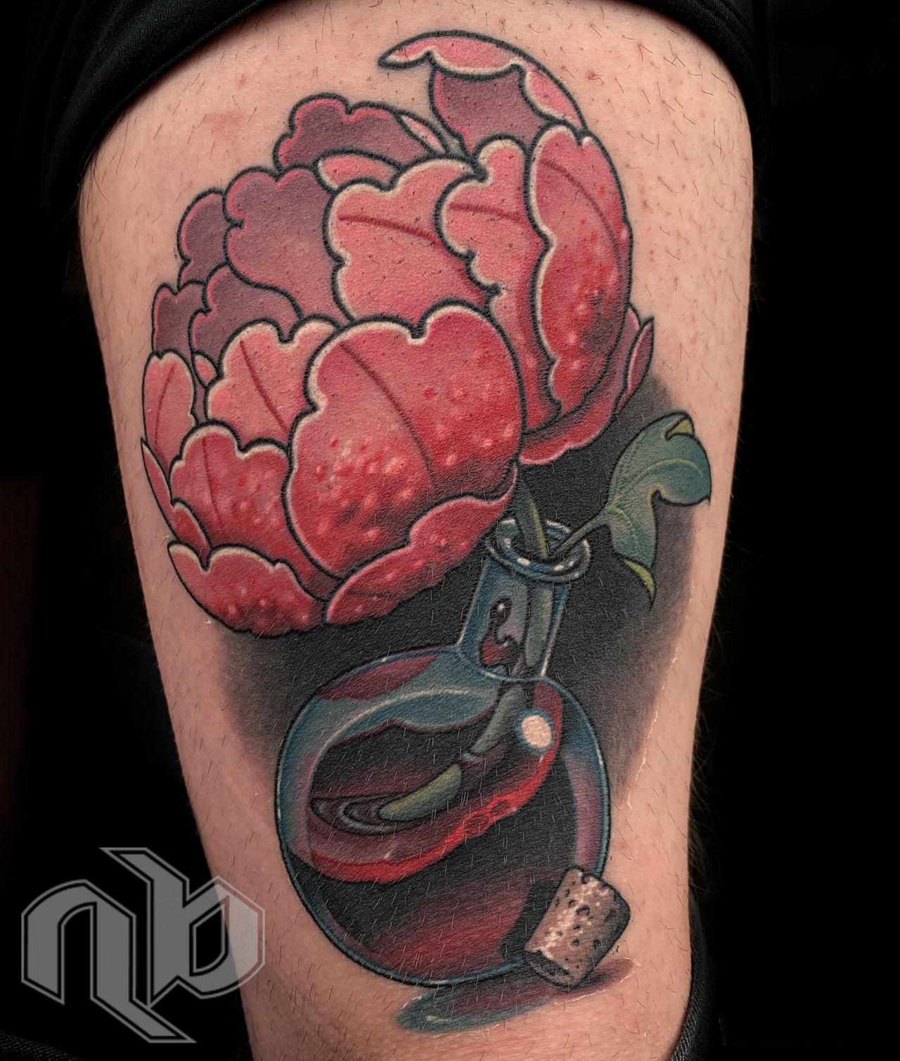 Close-up of a leg tattoo depicting a red-pink peony emerging from a rounded dark blue potion bottle filled with blood, with a cork stopper.